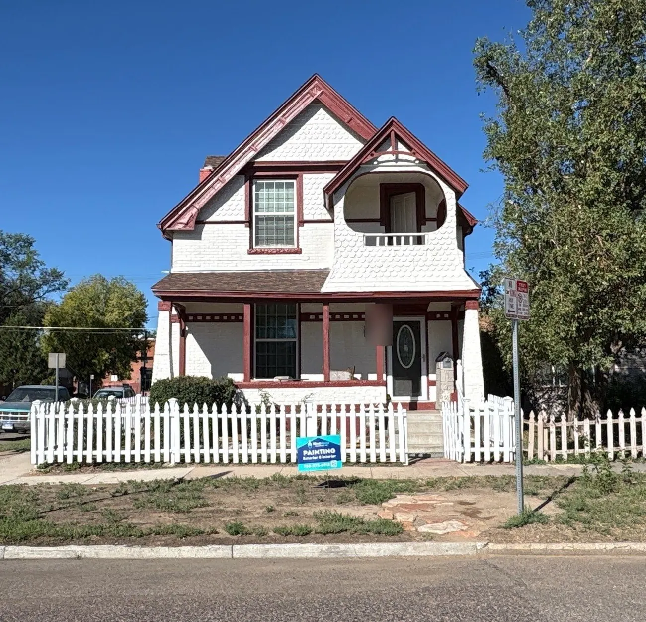 Restored 1890 Victorian in Denver's City Park neighborhood painted Sherwin-Williams Shoji White with Carriage Door red trim, fascia, and porch posts