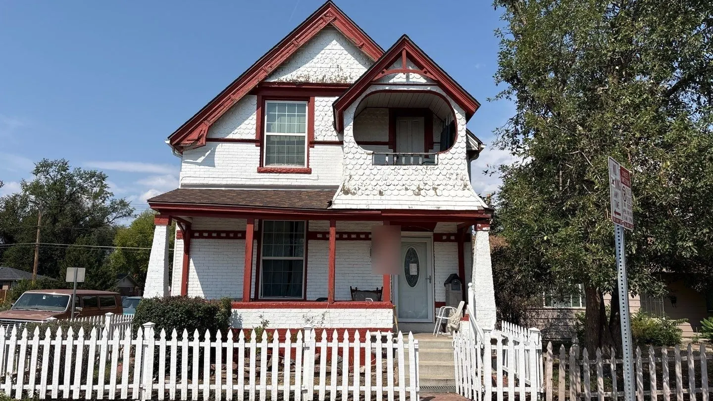 Front of an 1890 Victorian in Denver's City Park neighborhood before painting, with weathered white fish-scale shingles in the gables and faded red trim