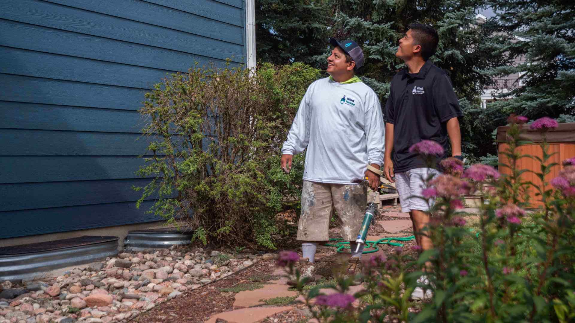 Photo of a kind home project manager and a kind home painter walking an exterior painting project during spring
